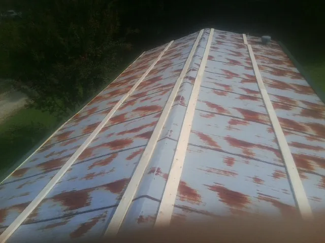 Rusted metal roof panels with new wood purlins before replacement — Storm Damage Roof Repair in Bondurant by Roofing Brothers