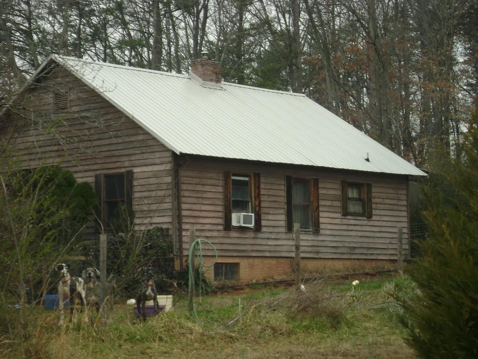 White metal roof on an old wood sided farmhouse, from a Metal Roof Installation job in Bondurant